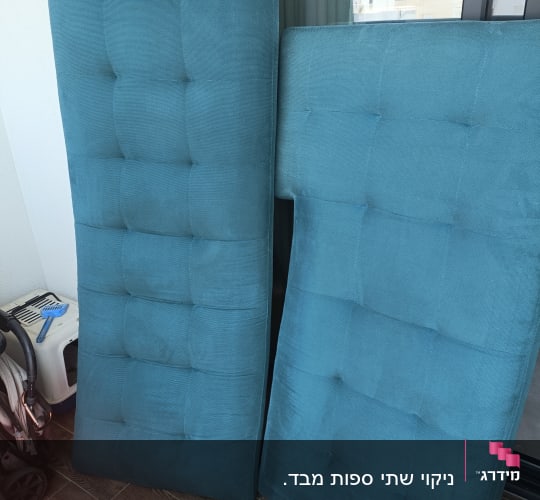 שני מזרנים כחולים עומדים על הרצפה ליד חלון